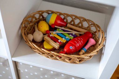 Hasır bir sepette ahşap renkli müzik aletleri. Montessori kumaşı. Evde eğitim kavramı. Çevre dostu oyuncak
