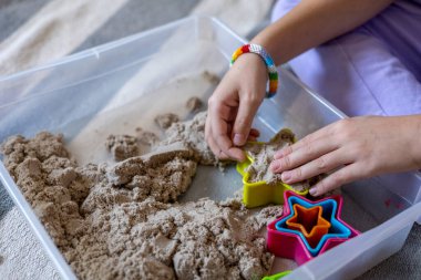 Çocuk duyusal bir kutuda kumla oynuyor. Montessori kumaşı. Evde eğitim kavramı. Çevre dostu oyuncak