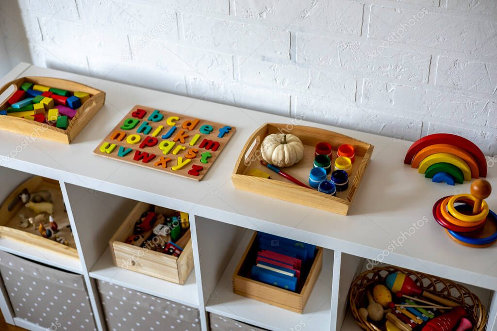 White shelf with baskets and drawers in the children room. Montessori material. Home schooling concept. Eco-friendly toy