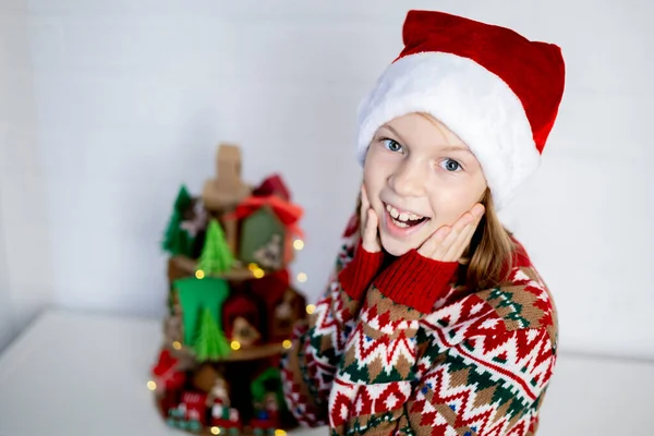 Dziewczyna Kapeluszu Świętego Mikołaja Patrzy Kalendarz Adwentu Koncepcja Przygotowania Świąt — Zdjęcie stockowe