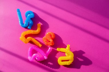 Oyuncak pop müzik eğitimi konsepti. Çocuklar arasında popüler bir oyuncak. Pembe arka plan. Düz yatıyordu