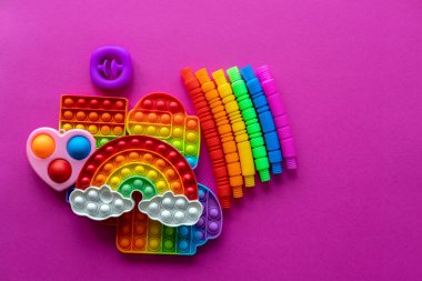 Stres önleyici oyuncaklar eğitim konsepti. Çocuklar arasında popüler bir oyuncak. Pembe arka plan. Patlat ve tüp oyununu patlat. Düz yatıyordu