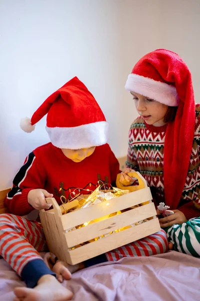Zero Marnowania Świąt Dzieci Piżamach Siedzą Łóżku Patrzą Zabawki Choinkę — Zdjęcie stockowe