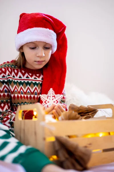 Święta Bez Marnotrawstwa Dziewczynka Piżamie Siedzi Łóżku Patrzy Zabawki Choinkę — Zdjęcie stockowe