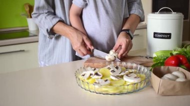 Erkek çocuk annesinin mutfakta duran sebzeli ratatouille 'i pişirmesine yardım ediyor. Aile gelenekleri. Evde Montessori eğitimi. Vejetaryen gıda konsepti.