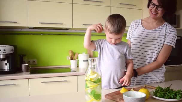 成年妇女正在准备和儿子一起喝柠檬水 夏天的炎热 素食概念 呆在家里 — 图库视频影像
