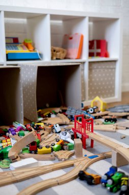 Toys are scattered around the room. Wooden rails and a steam locomotive. Defocus. Educational games for young children. Kindergarten.
