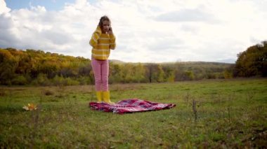 Çocuk çayırdaki piknikten sonra kırmızı bir battaniye aldı. İnsanlar doğayla bütündür. Sağlık konsepti. Denge ve sakinlik hissi.