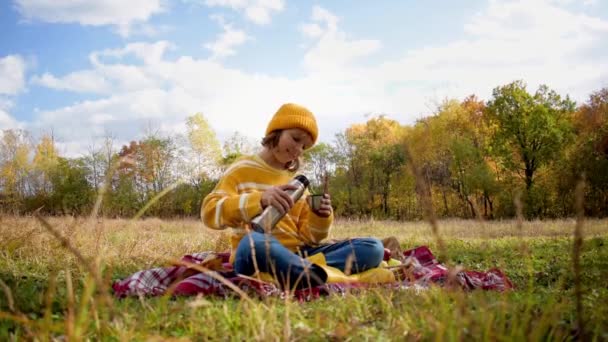 在阳光明媚的秋日 徒步旅行的女孩在秋天的森林里倒热茶 放松身心 慢动作视频 真实性 平衡感和平静感 — 图库视频影像