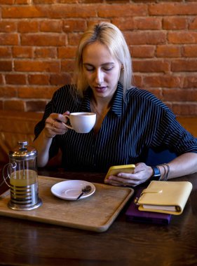 Genç bir kadın elinde sıcak bir içecek olan beyaz bir bardak tutuyor. Çay zamanı. Antioksidanlı yeşil tonik çayı