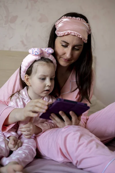 母親と彼女の子供はベッドの上に横たわるデジタルタブレットPcの画面で見ています 誰かに電話して おはようございます 幸せな家族の概念 ゆったりとした時間 — ストック写真