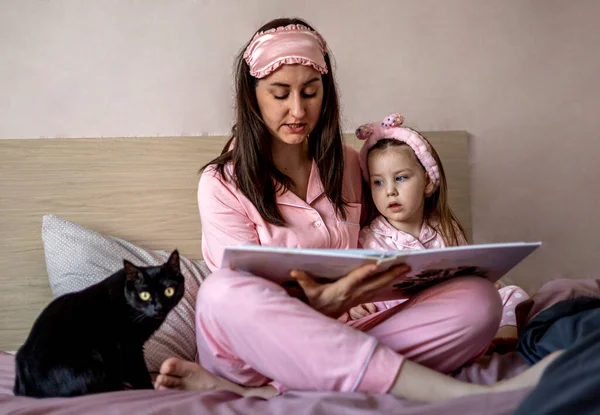 母さんは本を子供に読んでいる 初期の教育リテラシー開発 幸せな家族だ 本物の率直な子供時代のライフスタイル 親の女性はドーターに時間を費やしています 子供に読書を教えること — ストック写真