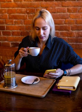 Genç bir kadın elinde sıcak bir içecek olan beyaz bir bardak tutuyor. Çay zamanı. Antioksidanlı yeşil tonik çayı