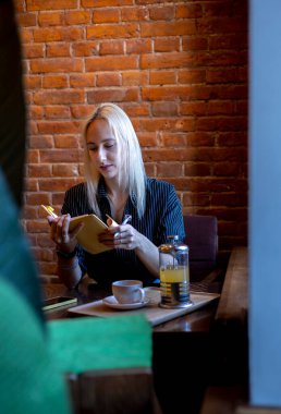 Takım elbiseli bir kadın pencerenin yanındaki not defterine girdi. Sağlık konsepti. Yemek molası. Ofis çalışanı.