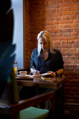 Takım elbiseli bir kadın pencerenin yanındaki not defterine girdi. Sağlık konsepti. Yemek molası. Ofis çalışanı.
