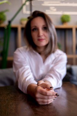 Kadın ofis çalışanı bir kafede oturuyor. Bir kadın portresi. Freelancer öğle yemeğini bekliyor.