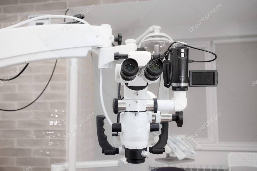 Dental microscope with video camera. against the background of modern dentistry. Medical equipment. operating microscope. with swivel double binoculars. dental microscope. an office in a white office.