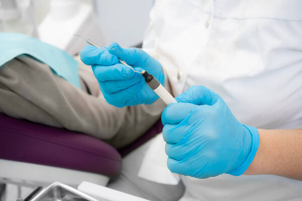 Composite filling material used in dentistry. Dentists hands in sterile gloves close-up.