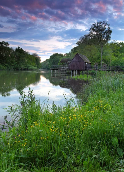 Spring landscape at sunset with watermill and river — Stock Photo, Image