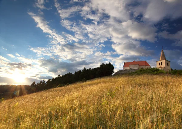 Chiesa cattolica con sole e strom sullo sfondo — Foto Stock