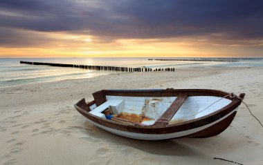 Boat on beautiful beach in sunrise clipart