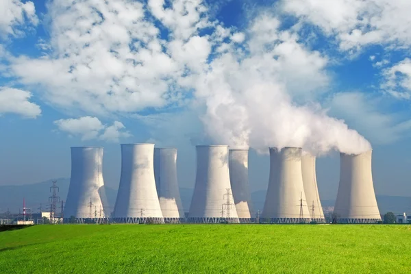 Nuclear power plant with yellow field and big blue clouds — Stock Photo, Image