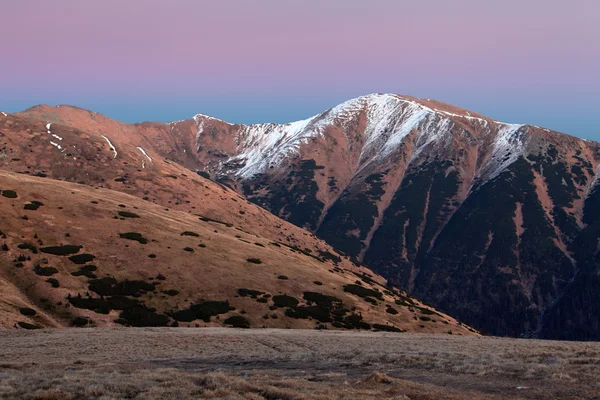 Un panorama de la puesta de sol helada en las montañas de belleza desde el pico Strazov —  Fotos de Stock