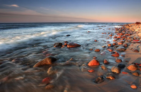 Веселий захід сонця на кам'яному пляжі — стокове фото