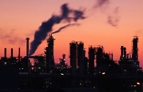 Нафтопереробний завод силует над заходом сонця — стокове фото