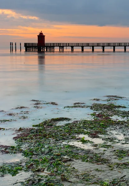 Träbrygga och fyr i lignano — Stockfoto