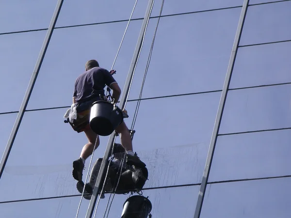 Homme nettoyant les fenêtres d'un immeuble de grande hauteur — Photo