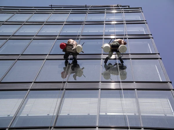 Windows üzerinde bir yüksek bina temizlik bir adam — Stok fotoğraf