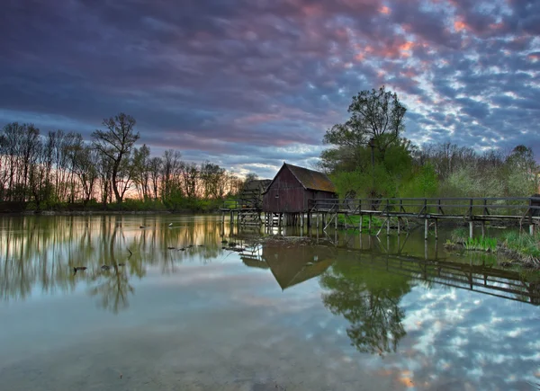 川と劇的な夕日と水車小屋. — ストック写真