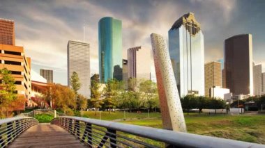 Time lapse at sunset in Houston, Texas, USA. Wooden bridge in Buffalo Bayou Park, with a beautiful view of downtown Houston (skyline / skyscrapers) in background on a summer day.