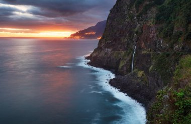 Madeira Adası - Miradouro do Veu da Noiva 'dan şelale manzaralı Atlantik okyanusu üzerinde dramatik gün doğumu