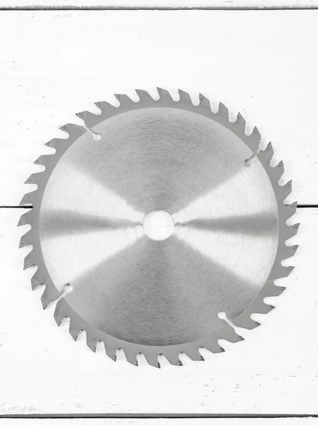 白い木製の背景に金属製の円形ののこぎりディスク — ストック写真
