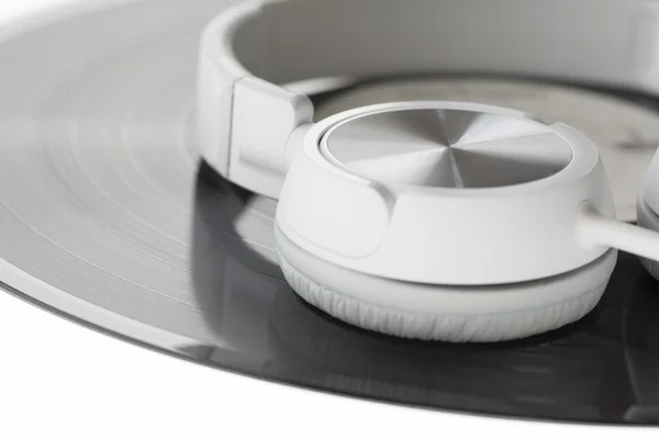 DJ tipi kulaklıklar üzerinde beyaz izole bir vinil rekor üstüne