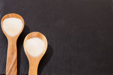 Kolajen tozu, siyah arkaplanda. Ek protein alımı. Cilt, kemik, eklem ve bağırsak için doğal güzellik ve sağlık desteği.