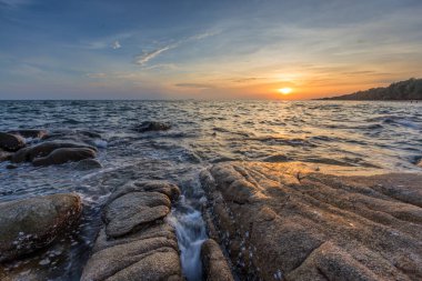 Gün batımında Tayland, Rayong 'da bir rock plajı..