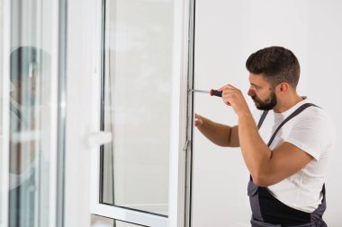 içerideki pvc pencereleri tamir eden işçiler