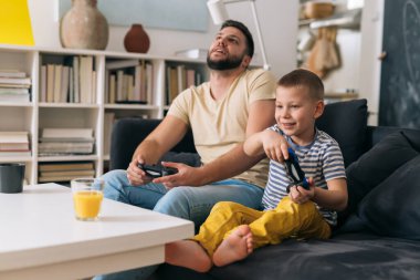 baba ve oğul evde video oyunu oynuyorlar.