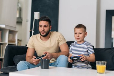 baba ve oğul evde video oyunu oynuyorlar.