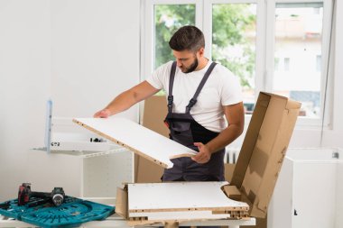 Profesyonel işçi dolabı içeride monte ediyor.