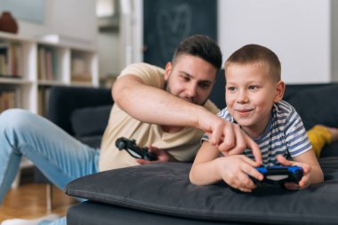 baba ve oğul evde video oyunu oynuyorlar.