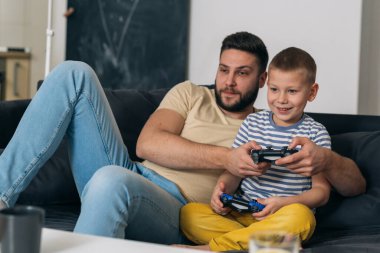baba ve oğul evde video oyunu oynuyorlar.