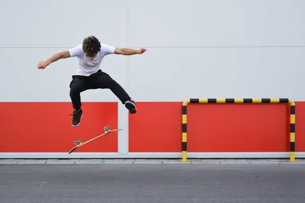 Skater Saltando Frente Pared Roja Blanca —  Fotos de Stock