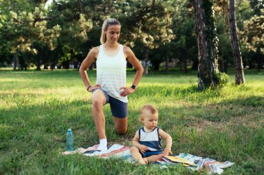 Anne ve oğlu dışarıda parkta fiziksel egzersiz yapıyorlar.