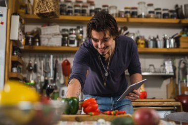 Adam mutfakta yemek yapmayı öğreniyor.