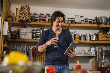 Adam mutfakta yemek yapmayı öğreniyor. dijital tablette tarifler aranıyor