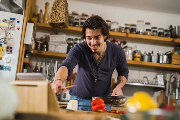 Adam mutfakta yemek yapmayı öğreniyor.